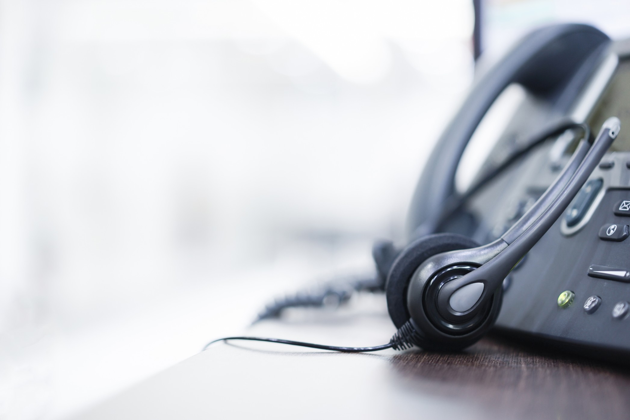 close-up-on-headset-devices-of-call-center-career-with-telephone-voip-on-table-of-helpdesk-agency_t20_NGr672